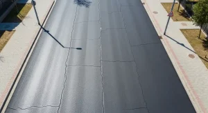 Aerial view of asphalt road showing early cracks, highlighting pavement surface texture and durability concerns.