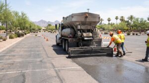 Slurry seal machine applying a fresh asphalt surface treatment to an existing parking area